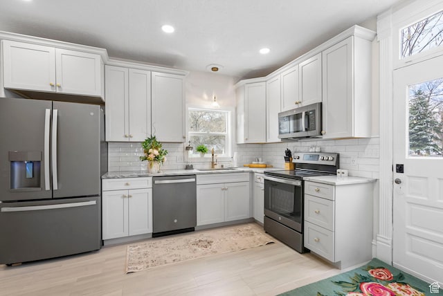 kitchen featuring plenty of natural light, backsplash, stainless steel appliances, and a sink
