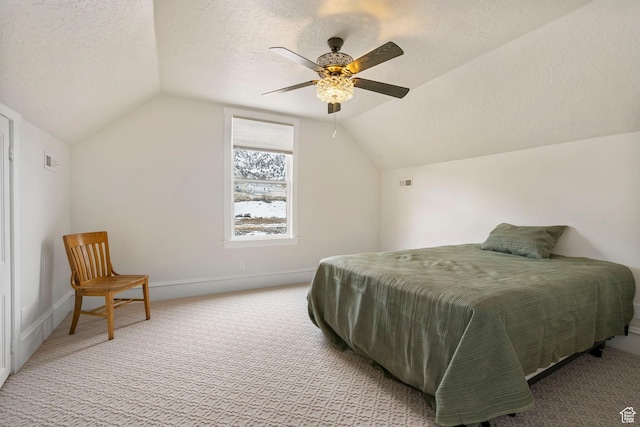 carpeted bedroom featuring baseboards, lofted ceiling, a textured ceiling, and a ceiling fan