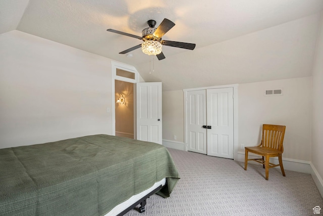 bedroom featuring a closet, visible vents, carpet, and lofted ceiling