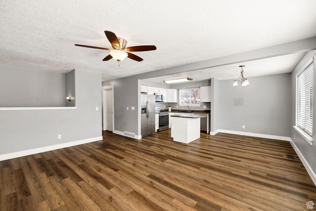 1170 N 730 E, Logan, UT 84341 - unfurnished living room with a sink, baseboards, plenty of natural light, and dark wood-style flooring