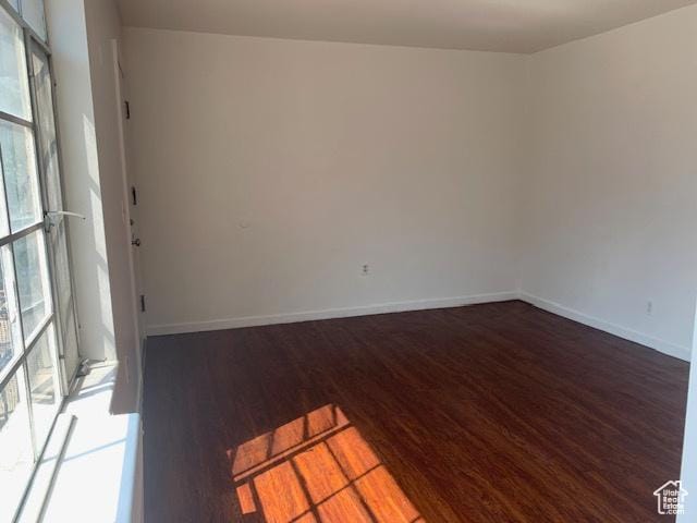 empty room with baseboards and wood finished floors