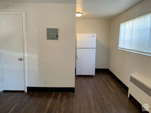kitchen with electric panel, radiator, freestanding refrigerator, and dark wood-type flooring