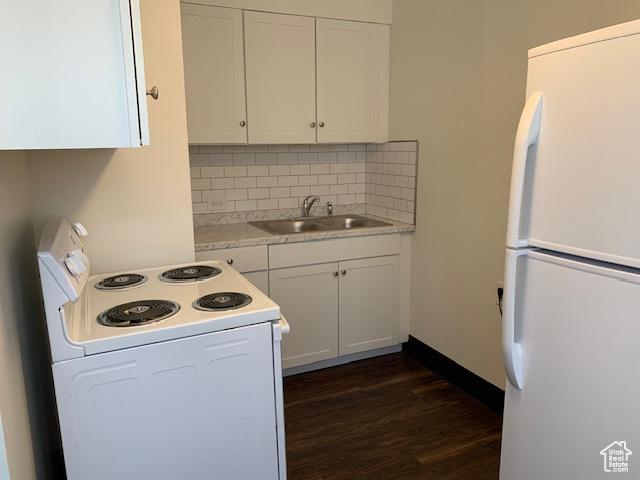 kitchen featuring backsplash, light countertops, white cabinets, white appliances, and a sink