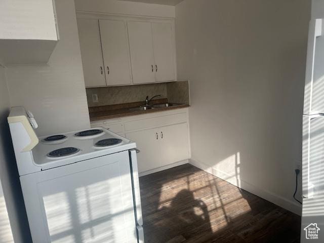 kitchen featuring white electric stove, dark wood finished floors, a sink, decorative backsplash, and white cabinets