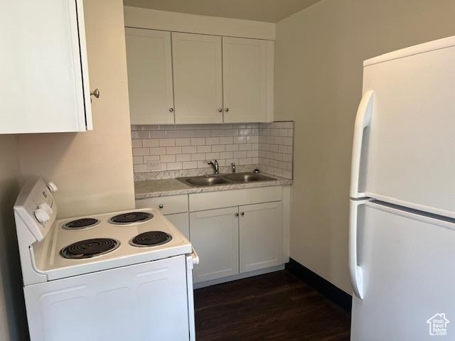 kitchen with white appliances, a sink, light countertops, white cabinetry, and tasteful backsplash