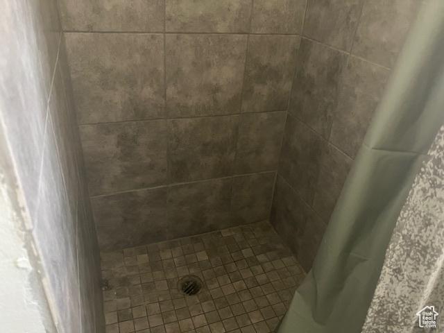 interior details featuring a tile shower