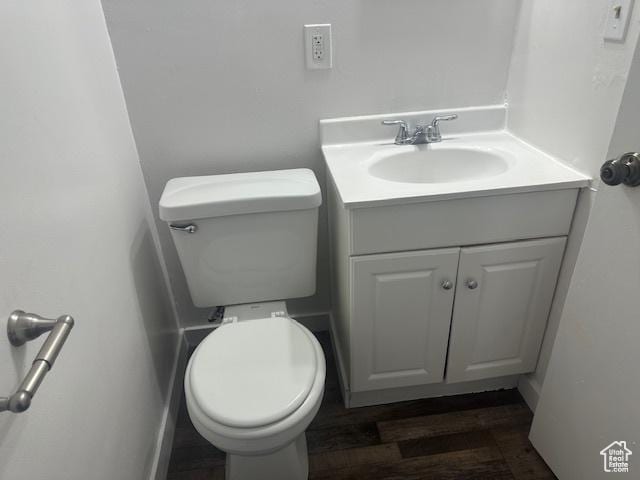bathroom with toilet, wood finished floors, and vanity