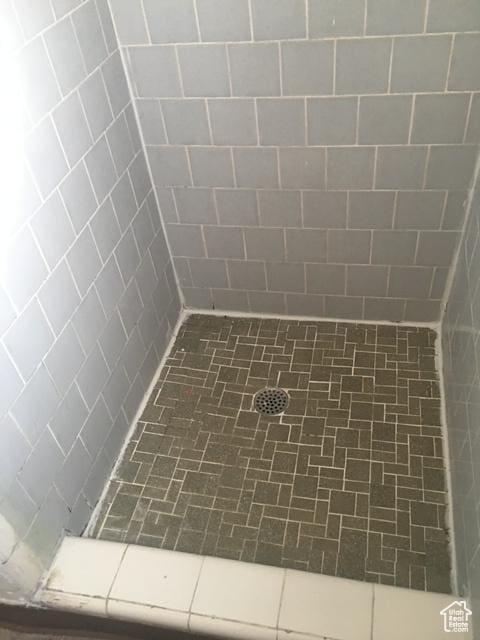 interior space with a tile shower and tile patterned floors