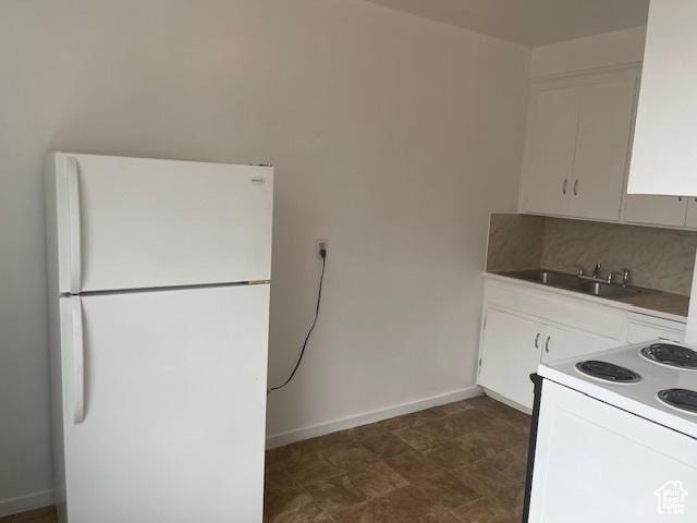 kitchen with decorative backsplash, white appliances, white cabinets, and a sink