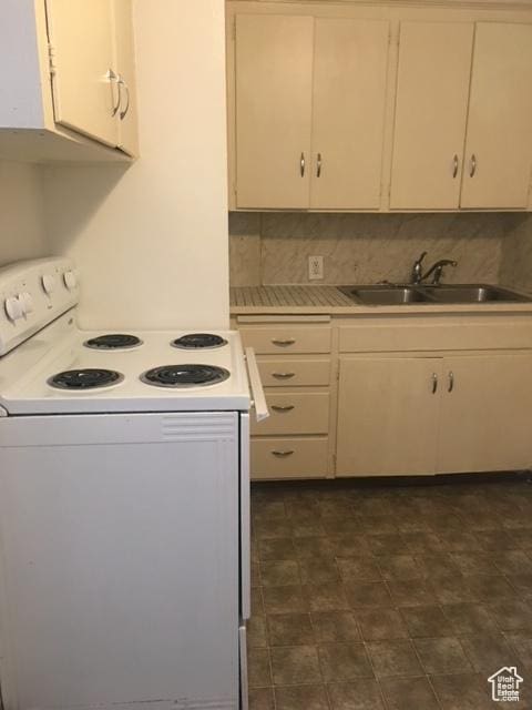 kitchen featuring white electric range oven, light countertops, backsplash, and a sink