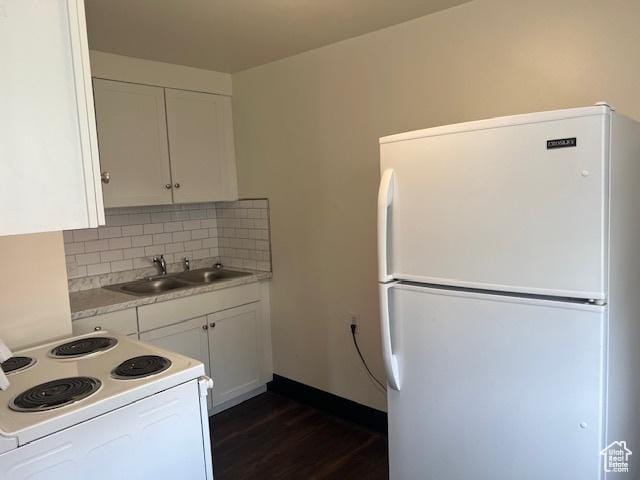 kitchen with white appliances, a sink, light countertops, white cabinets, and backsplash
