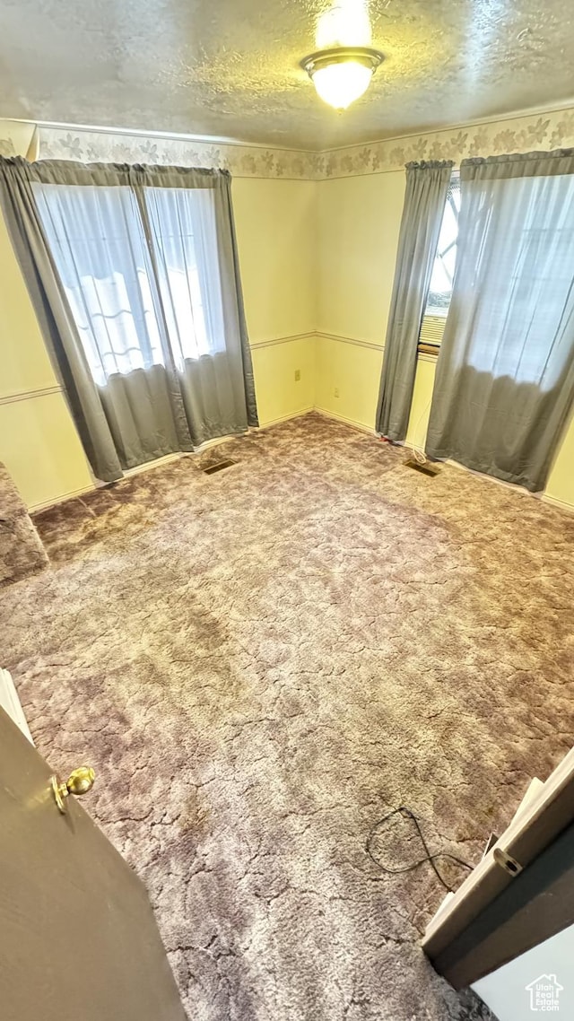 1010 Sullivan Rd, Ogden, UT 84403 - carpeted spare room featuring visible vents, a healthy amount of sunlight, and a textured ceiling
