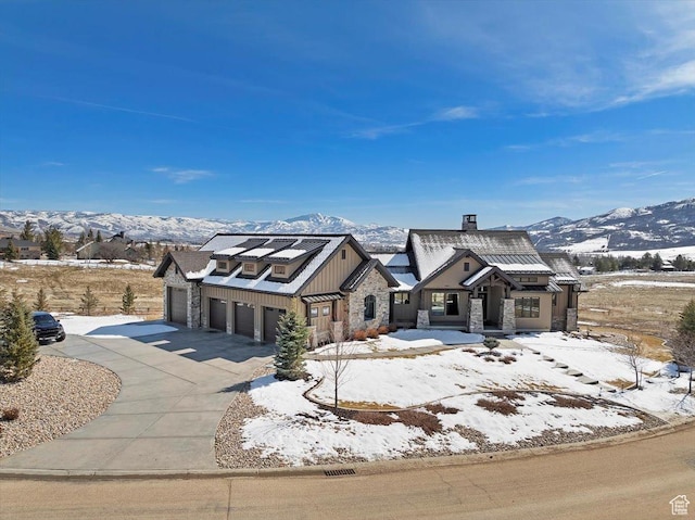 view of front of property with stone siding, driveway, metal roof, and a standing seam roof