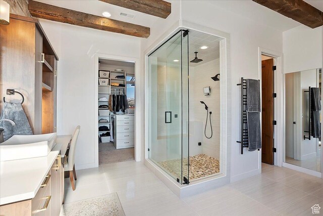 full bathroom with tile patterned floors, beamed ceiling, a walk in closet, a stall shower, and vanity