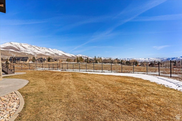 view of yard featuring fence and a mountain view