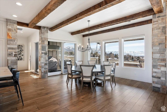 dining space featuring baseboards, a chandelier, beam ceiling, a mountain view, and dark wood-style flooring