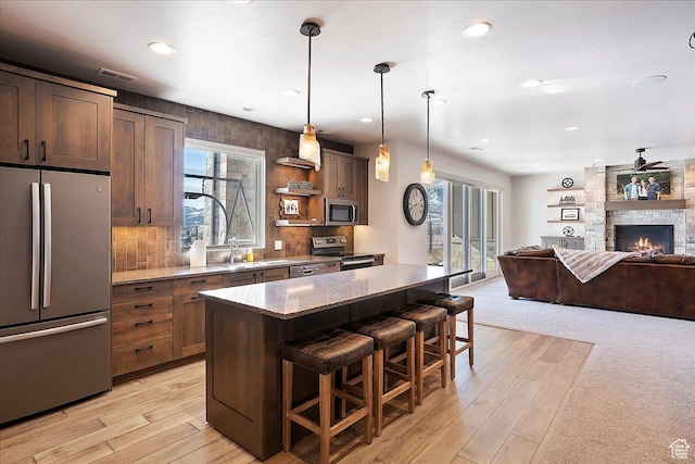 kitchen with a sink, a breakfast bar area, a healthy amount of sunlight, and stainless steel appliances