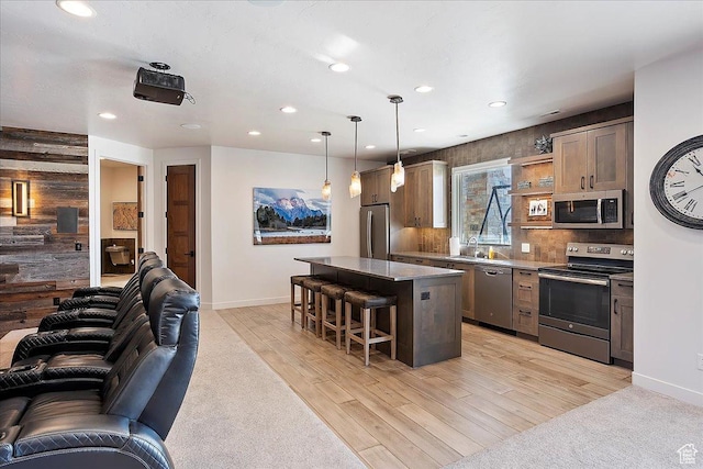 kitchen with a breakfast bar, open floor plan, appliances with stainless steel finishes, tasteful backsplash, and a center island