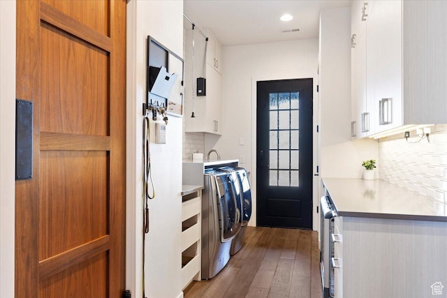 laundry area featuring cabinet space, light wood-style floors, visible vents, and washing machine and clothes dryer