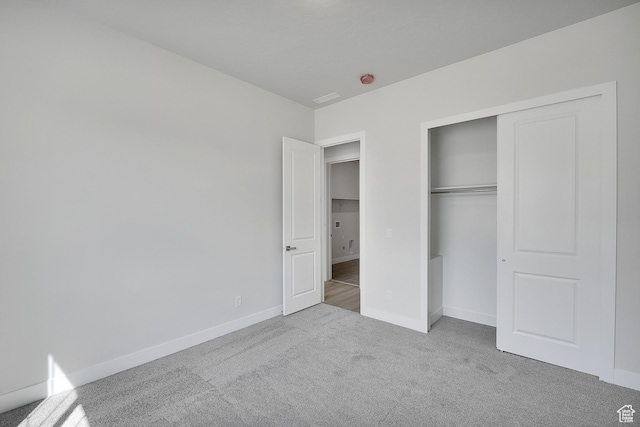 unfurnished bedroom featuring carpet flooring, baseboards, and a closet