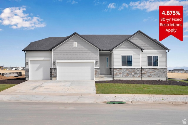 craftsman-style house featuring a garage, stone siding, and concrete driveway