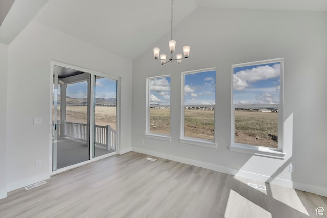 unfurnished dining area with a chandelier, light wood-style flooring, baseboards, and high vaulted ceiling