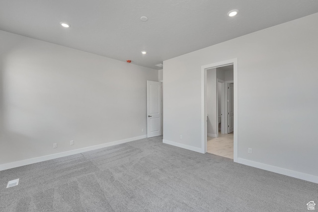 carpeted spare room featuring recessed lighting and baseboards