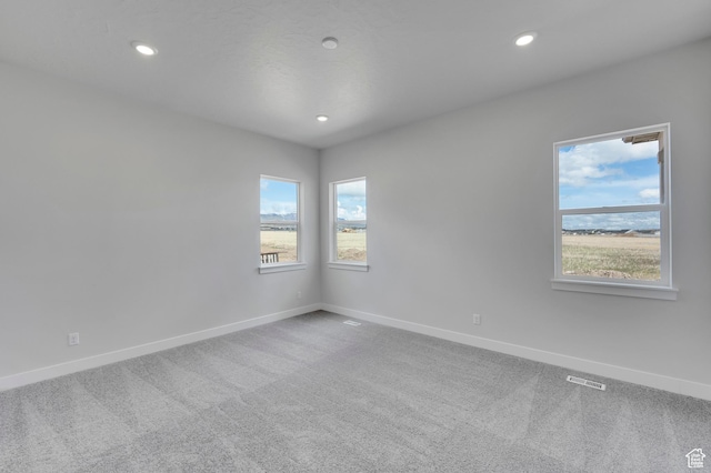 empty room with carpet, baseboards, and recessed lighting