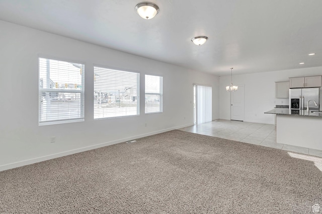 621 E Mayor Place Dr S, American Fork, UT 84003 - unfurnished living room with light tile patterned floors, light colored carpet, a chandelier, and baseboards