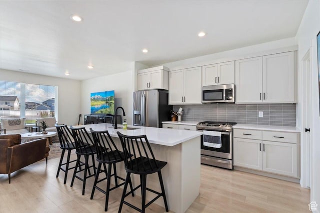 987 S 950 W, American Fork, UT 84003 - kitchen featuring a sink, a kitchen bar, tasteful backsplash, and appliances with stainless steel finishes