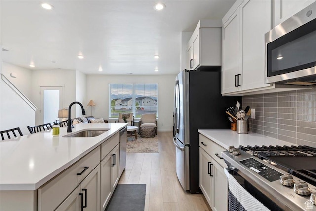 987 S 950 W, American Fork, UT 84003 - kitchen with tasteful backsplash, light countertops, light wood-style floors, stainless steel appliances, and a sink