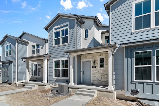 view of front of property with stone siding and central AC
