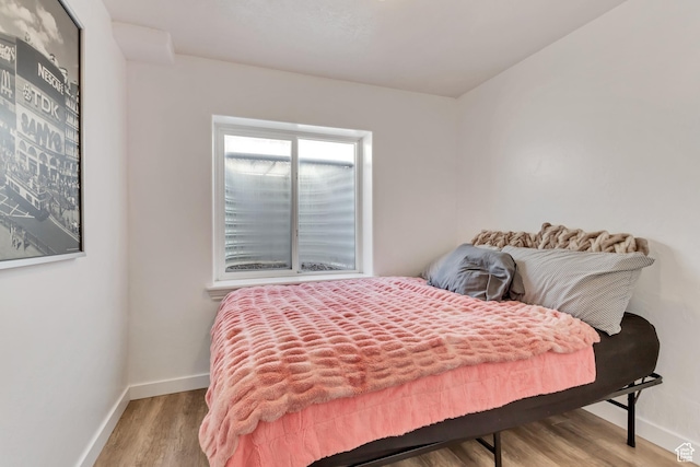 bedroom featuring baseboards and wood finished floors