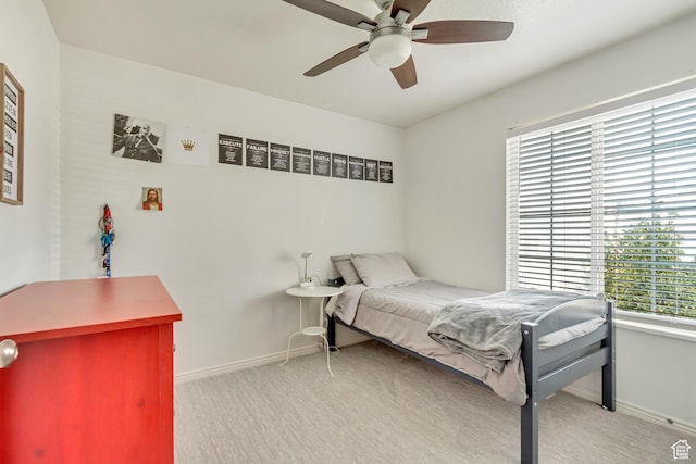 bedroom with light colored carpet, baseboards, and ceiling fan