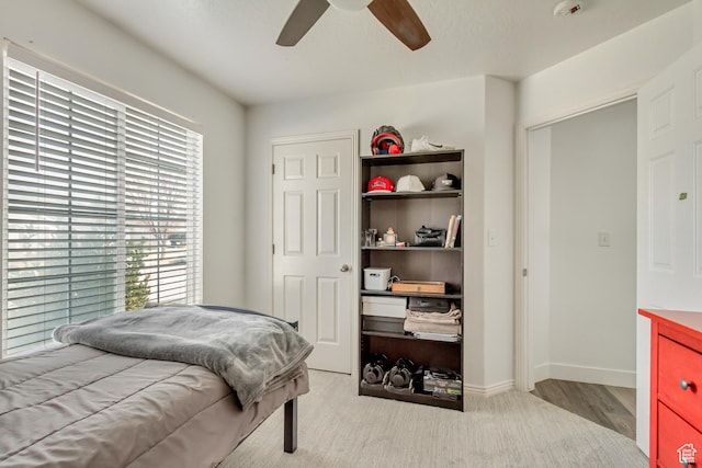 bedroom featuring wood finished floors, a ceiling fan, and baseboards