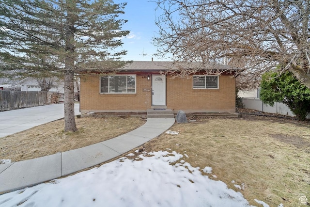 view of front of house featuring brick siding and fence