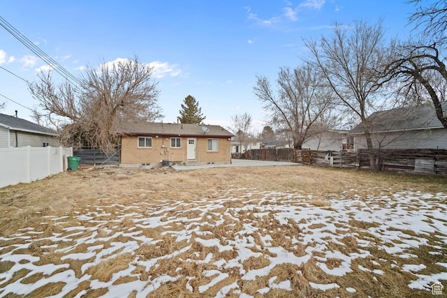 rear view of house with entry steps and a fenced backyard