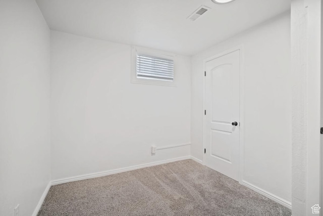 carpeted empty room with visible vents and baseboards