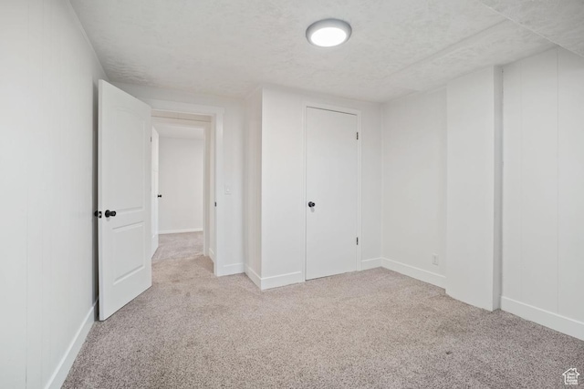 unfurnished bedroom featuring light colored carpet and a textured ceiling