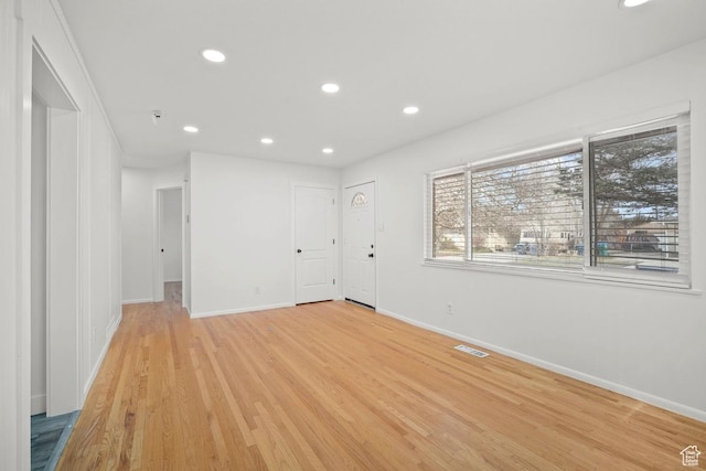 unfurnished room with recessed lighting, light wood-style floors, visible vents, and baseboards