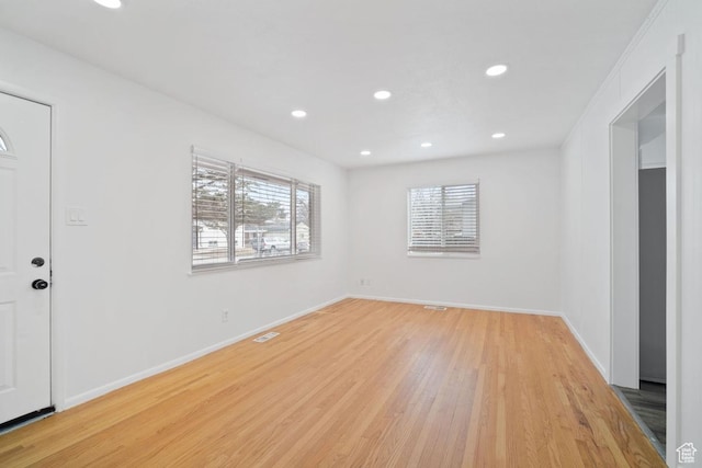 unfurnished room with plenty of natural light, recessed lighting, visible vents, and light wood finished floors