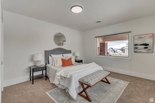 carpeted bedroom featuring baseboards and visible vents