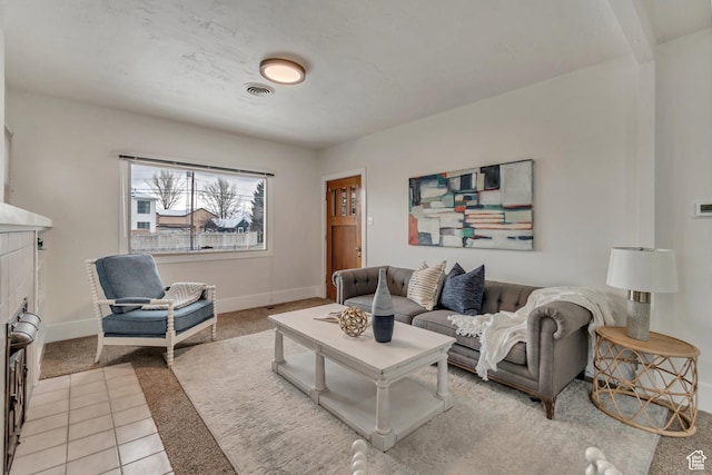 living room featuring light tile patterned floors, light carpet, baseboards, and visible vents