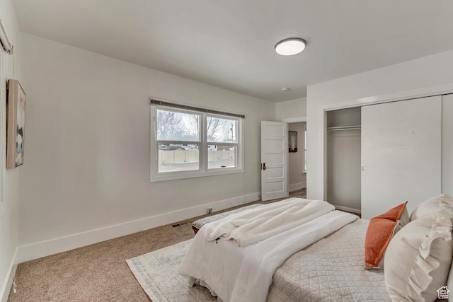 carpeted bedroom with baseboards, a closet, and visible vents