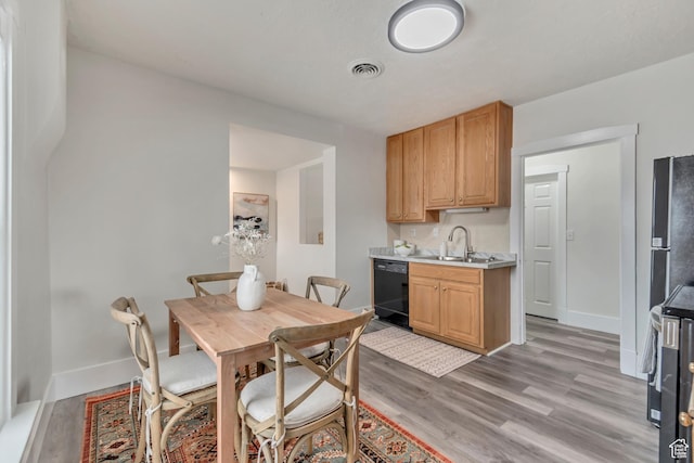 dining space with baseboards, visible vents, and light wood-style flooring