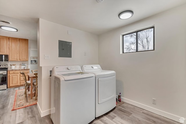 laundry room featuring baseboards, washing machine and clothes dryer, light wood finished floors, visible vents, and electric panel