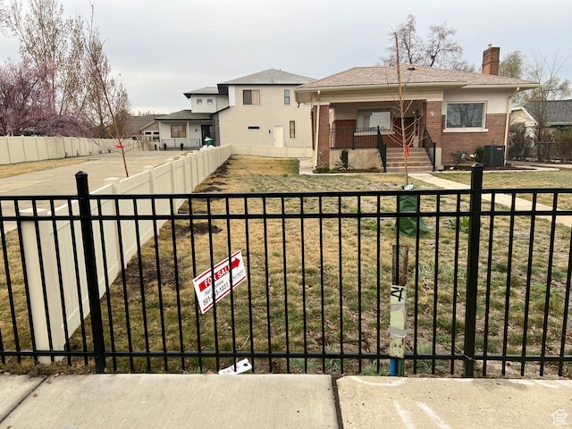 exterior space featuring cooling unit and a fenced front yard
