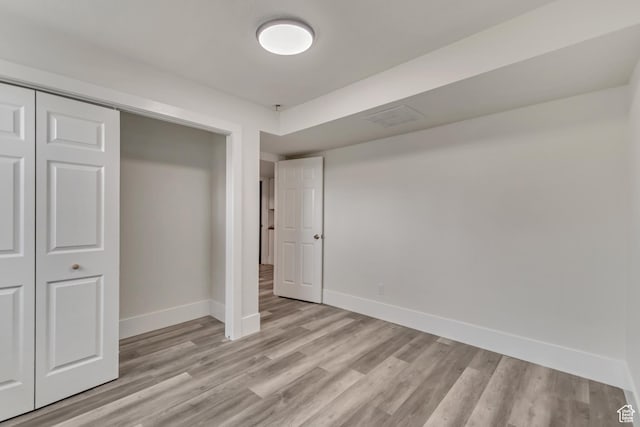 unfurnished bedroom with baseboards, visible vents, light wood-style flooring, and a closet