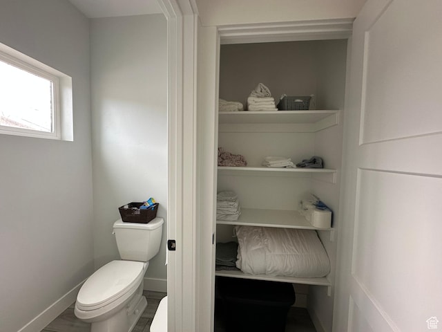 bathroom with toilet and baseboards