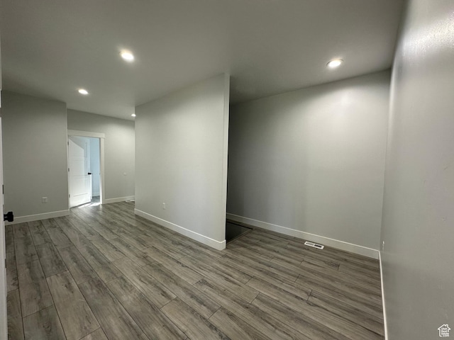 spare room featuring wood finished floors, recessed lighting, visible vents, and baseboards